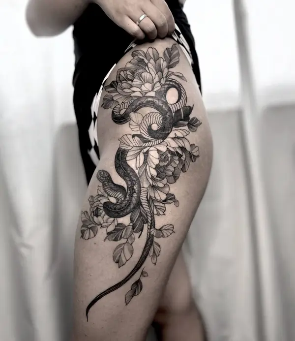 Snake and peony flower thigh tattoo for women by Diya Tattoo, Kathmandu, Nepal