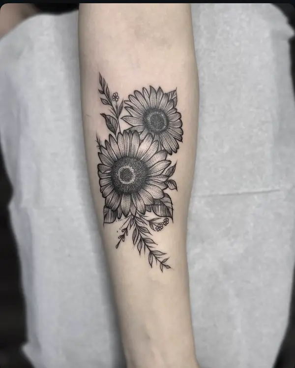 Black and grey sunflower forearm tattoo with small flowers by female tattoo artist in Kathmandu