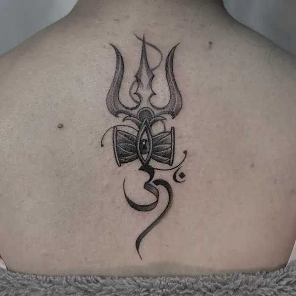 Trishul, damaru and Om script tattoo on upper back by Diya Tattoo, Kathmandu